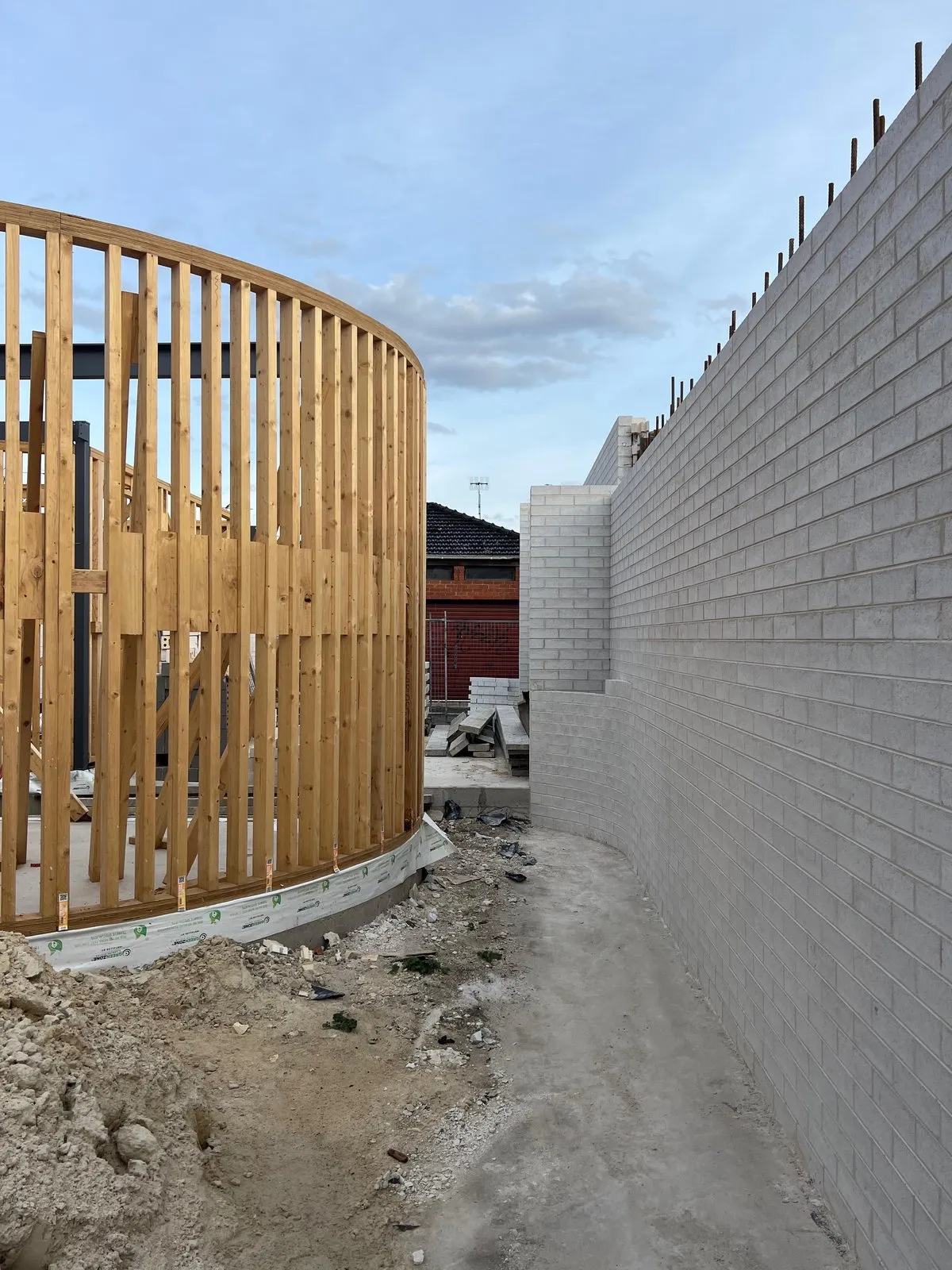 Eureka! under construction: a curved timber frame beside a pale brick wall